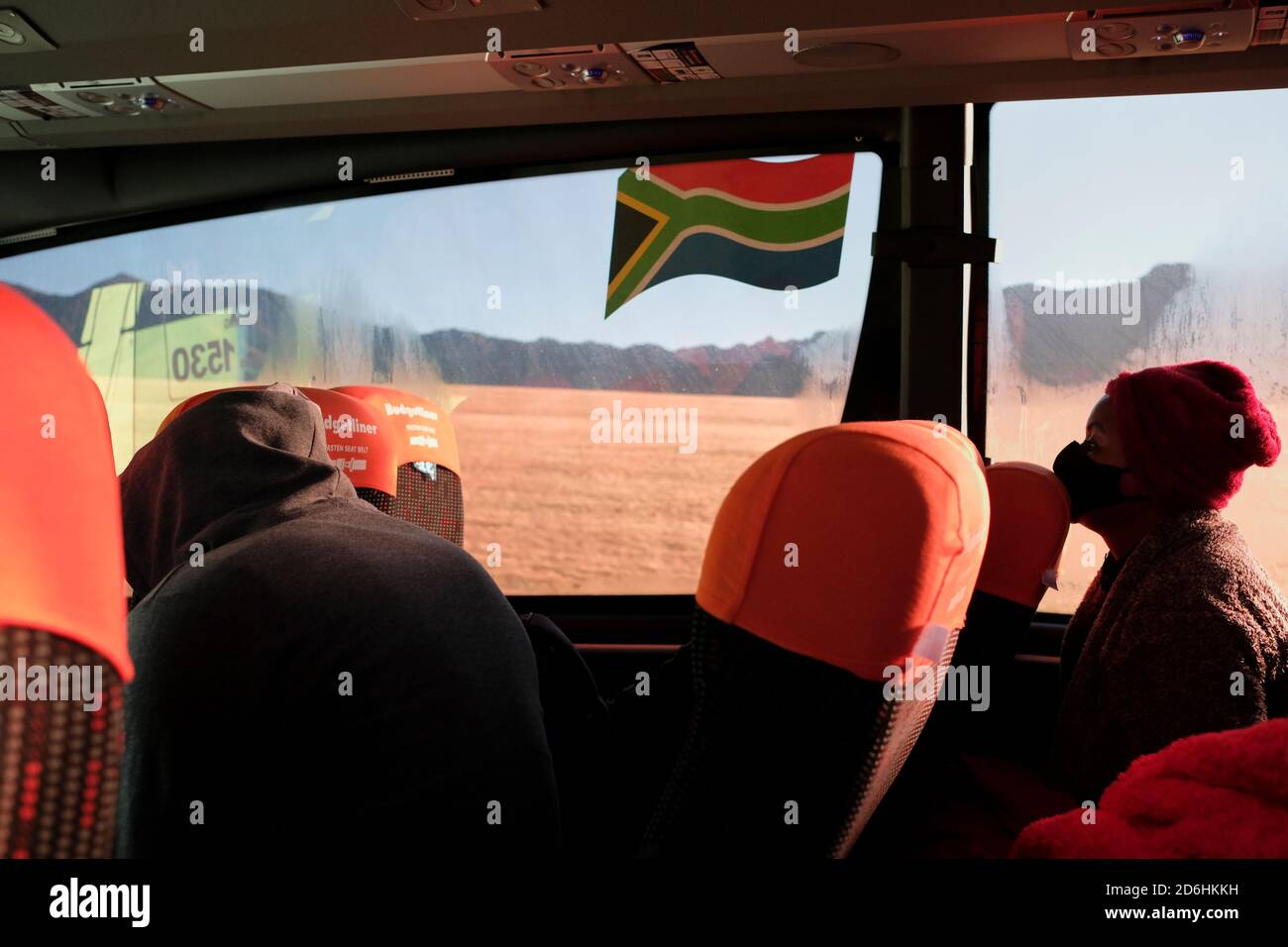 I passeggeri che indossano maschere durante il viaggio su un autobus (pullman) in Sud Africa durante il periodo pandemico di Covid-19. Foto Stock