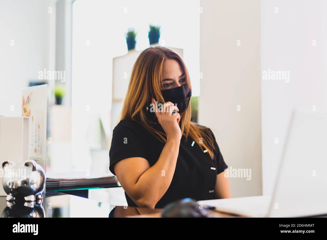 donna intraprendente che risponde al telefono dalla sua attività Foto Stock