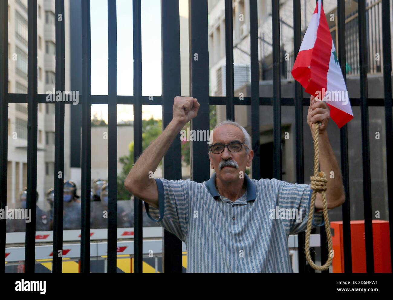 Beirut, Libano. 17 Ott 2020. Un attivista anti-governo mostra un gallone mentre si trova di fronte a una polizia in rivolta che protegge la Banca Centrale del Libano durante una marcia per celebrare il 1 ° anniversario delle proteste che sono state innescate dai libanesi contro la situazione economica e l'impasse politica. Credit: Marwan Naamani/dpa/Alamy Live News Foto Stock