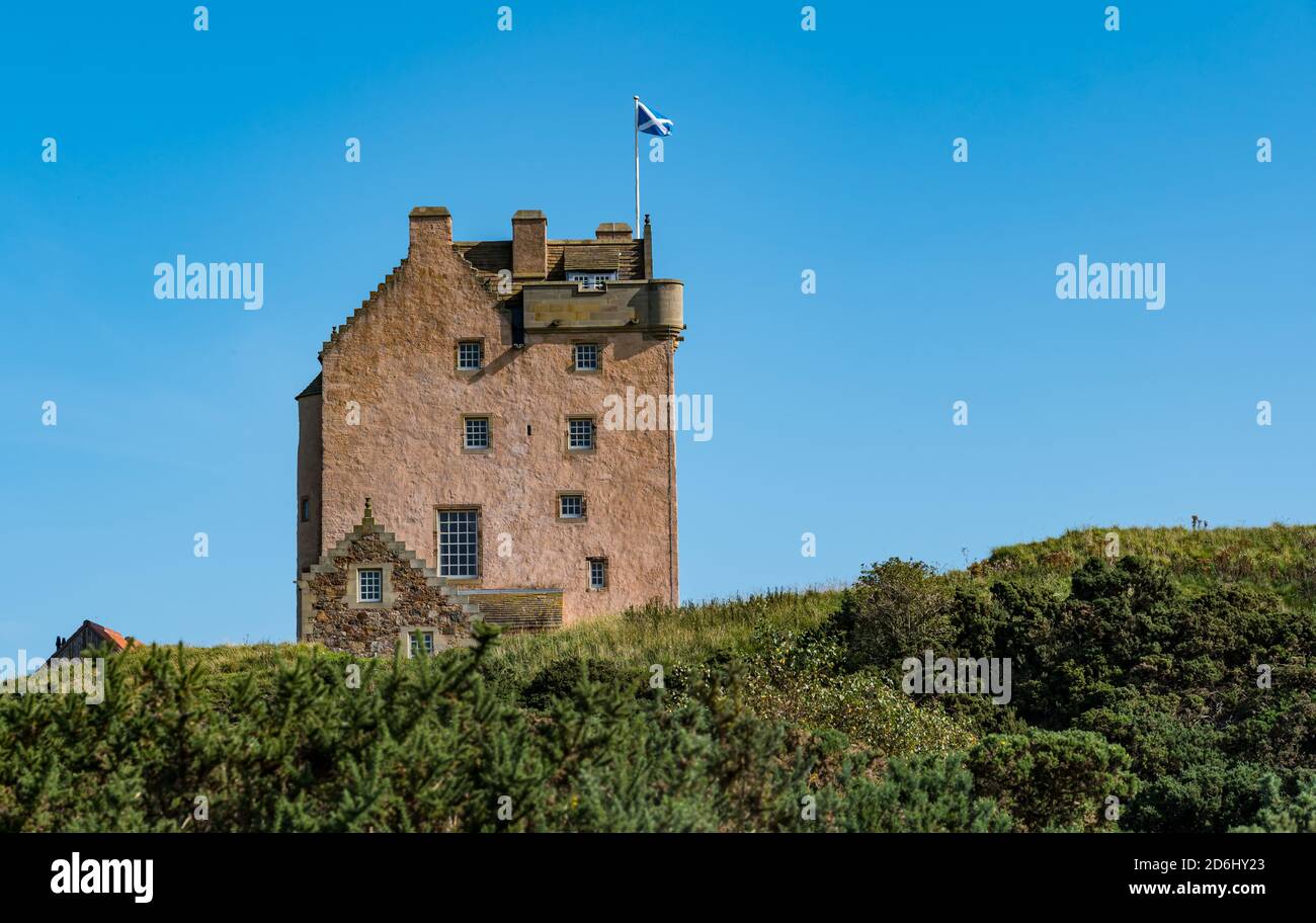 Edificio storico, la Torre di Fenton, una casa fortificata scozzese del XVI secolo che sorvola un saltire scozzese, East Lothian, Scozia, Regno Unito Foto Stock