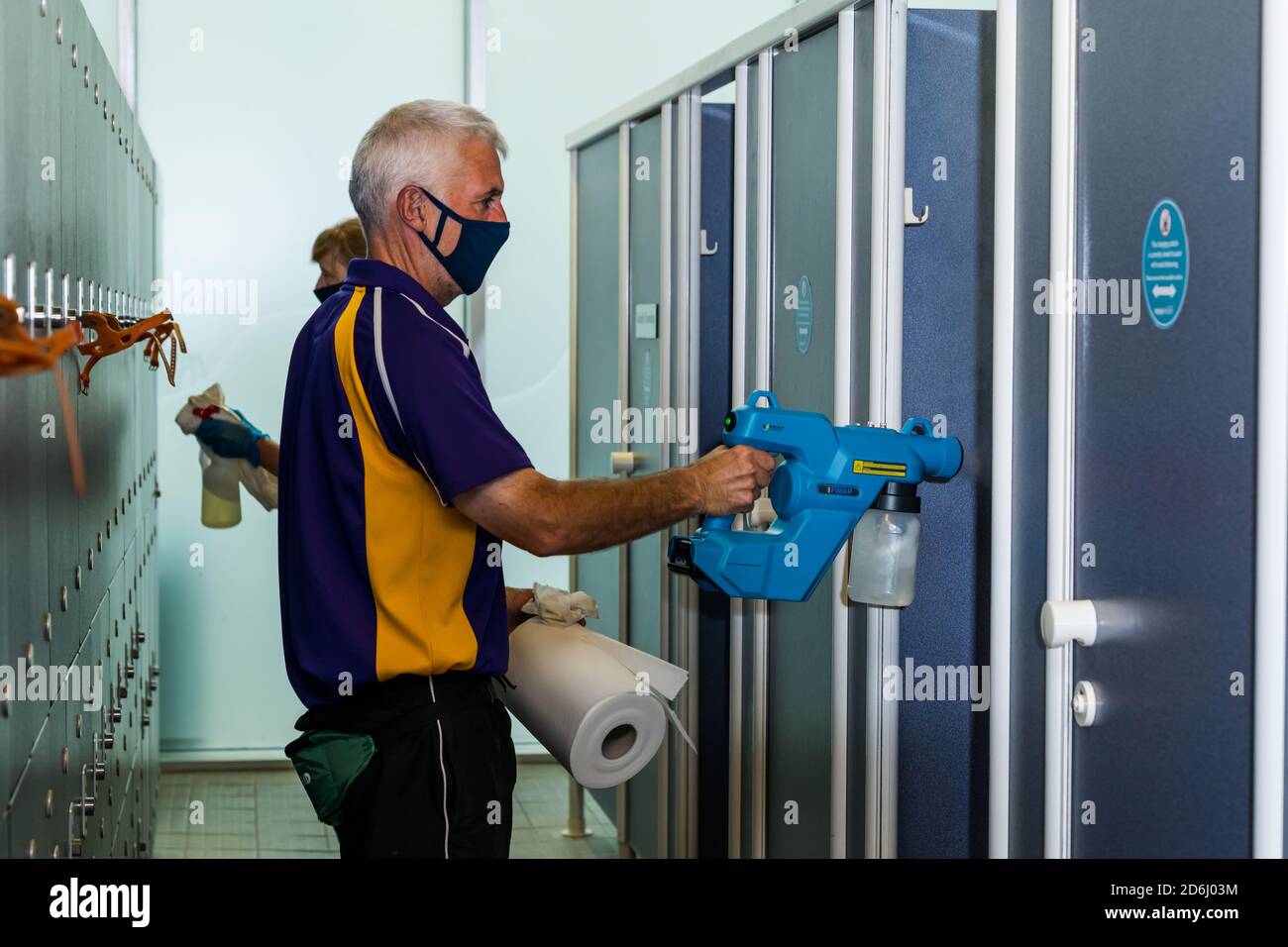 Il personale maschile indossa maschere per la pulizia dei cubicoli con spruzzatore igienizzante in Covid-19 pandemic, North Berwick centro sportivo, East Lothian, Scozia Foto Stock