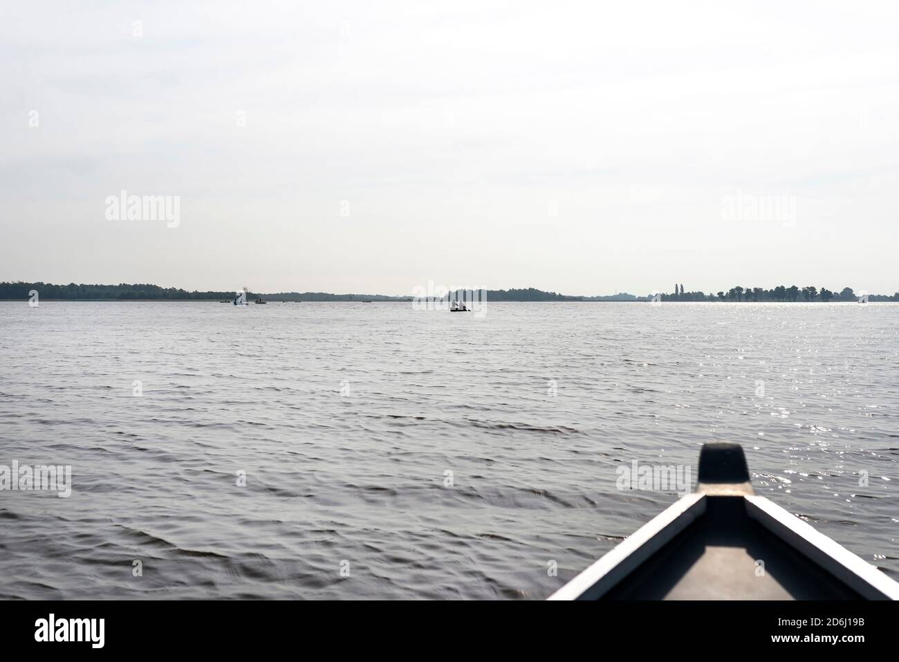Foto scattata da una barca di legno, persone visibili che galleggiano sulle barche, l'arco della barca è sfocato. Foto Stock
