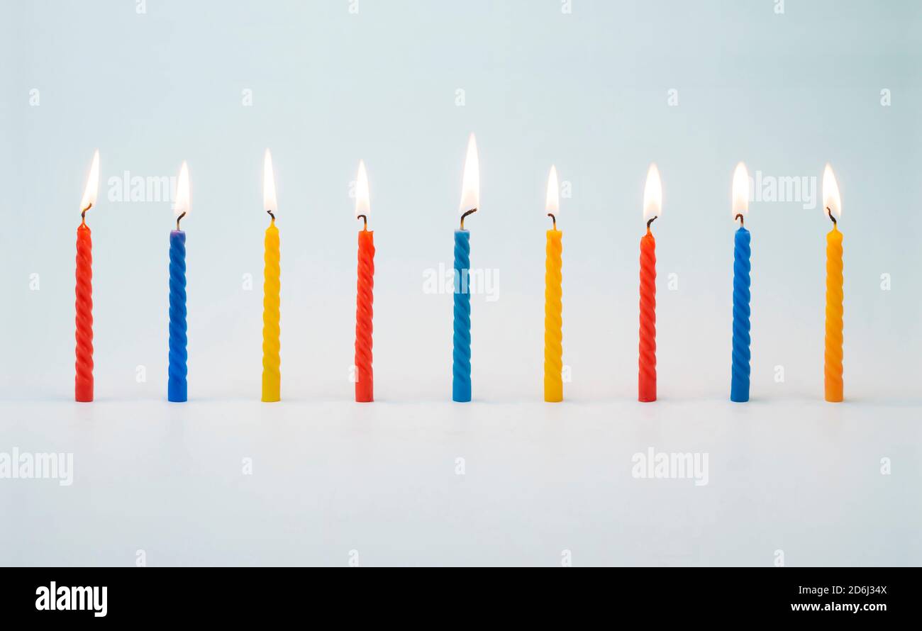 Candele colorate illuminate per torte di compleanno Foto Stock