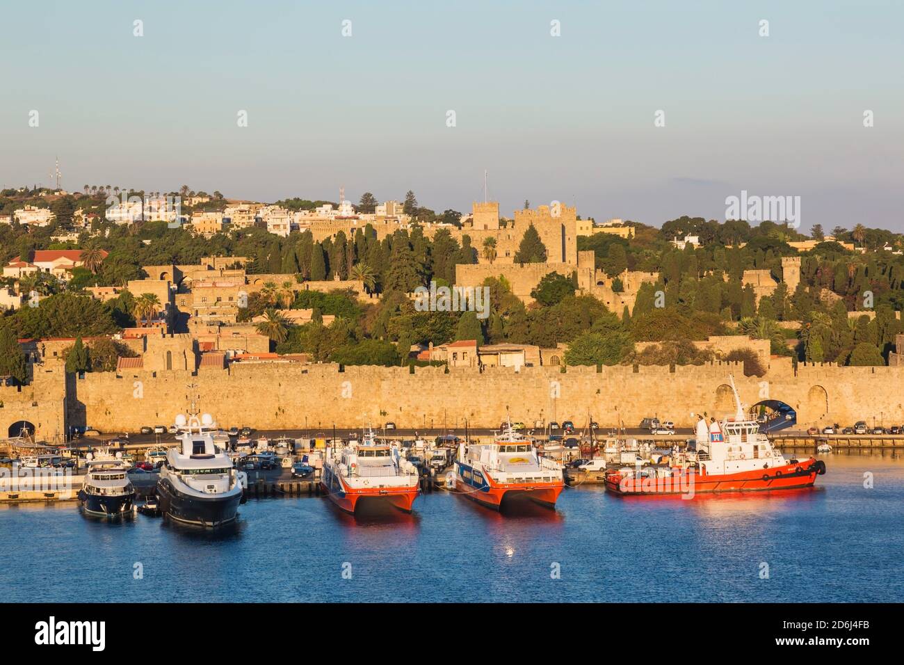 Traghetti attraccati nel porto commerciale e la città vecchia di Rodi con  mura di fortificazione all'alba, Rodi, Grecia Foto stock - Alamy