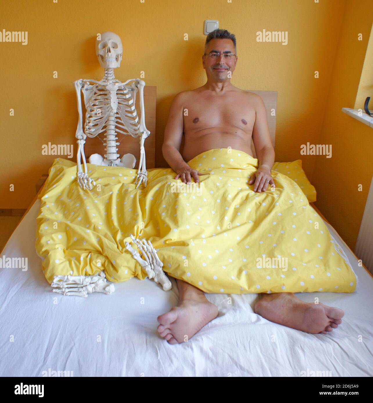 Uomo e scheletro a letto, Lauda, Germania Foto Stock