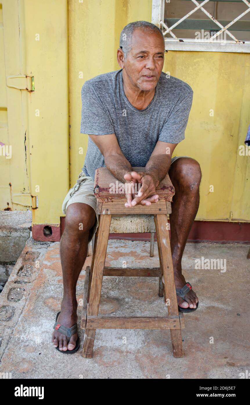Senior seduto dietro lo sgabello Foto Stock