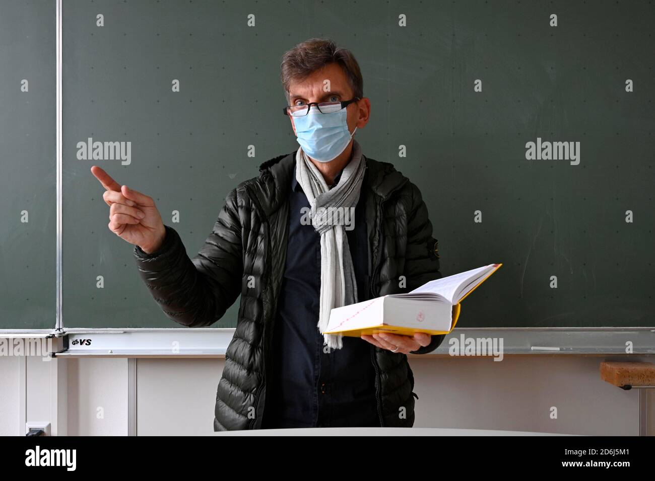 Insegnante con giacca invernale spessa, sciarpa e maschera facciale nell'insegnamento in classe, Corona Crisis, Stoccarda, Baden-Wuerttemberg, Germania Foto Stock