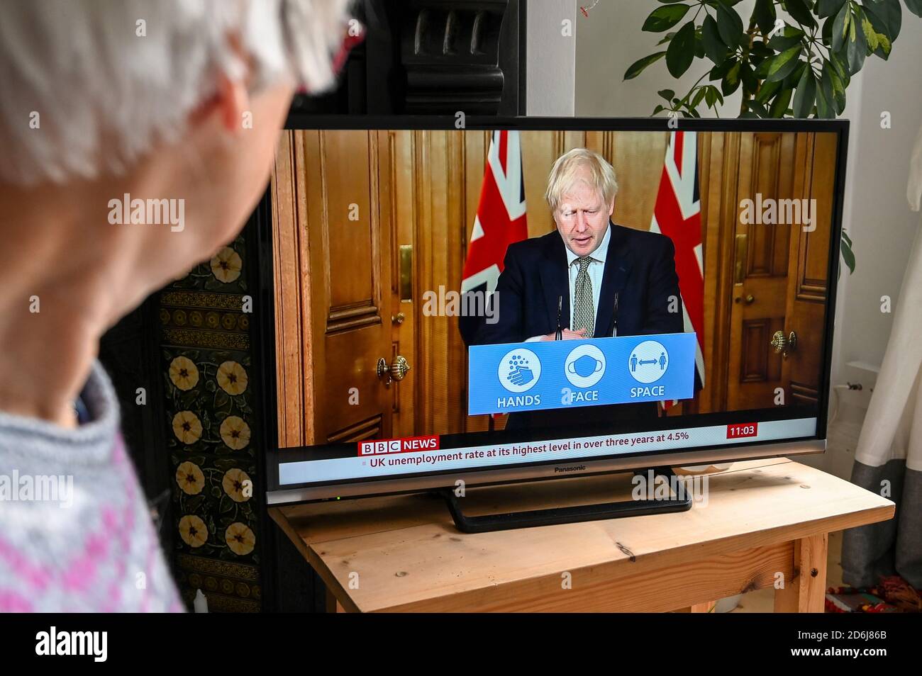 Il primo ministro Boris Johnson ha tenuto una conferenza stampa televisiva da Downing Street per quanto riguarda Covid-19 con il logo 'mani, spazio di faccia'. Foto Stock