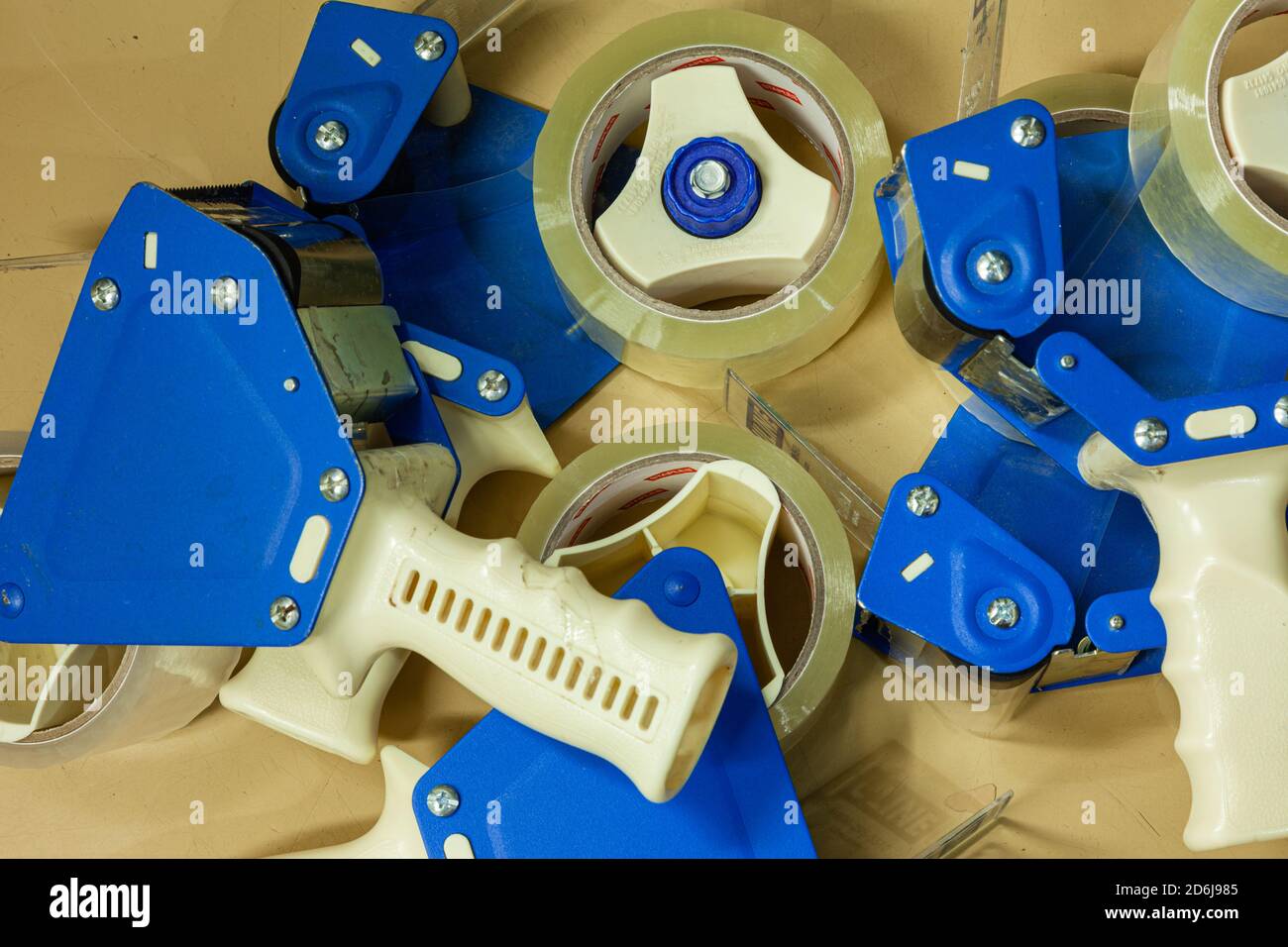 Array astratto di pistole a nastro adesivo in un impianto di confezionamento Foto Stock