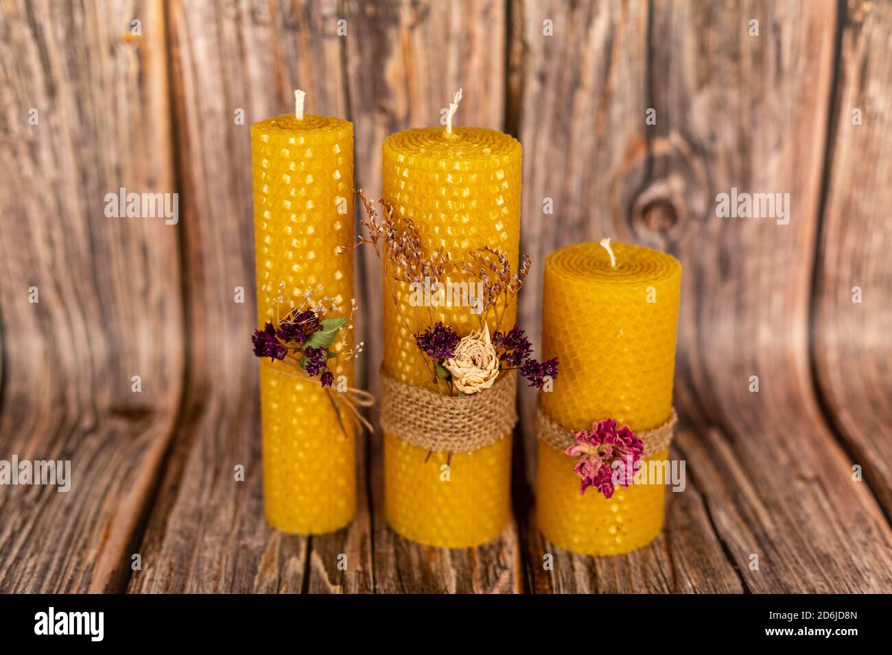 Candele di miele gialle fatte a mano di cera naturale su uno sfondo di tavole di legno. Elementi di materiali naturali. Composizione di Natale o Capodanno Foto Stock