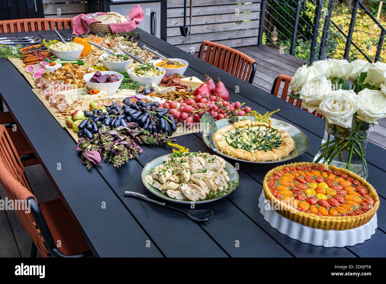 Tavola da pascolo con salumi, crostate, frutta e verdura sul tavolo in ambiente esterno Foto Stock