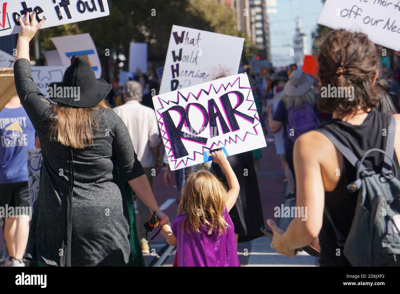 17 ottobre 2020. La marcia delle donne di San Francisco prima delle elezioni presidenziali degli Stati Uniti. Il protetore femminista della bambina tiene un cartello RUGGITO su Market Street. Foto Stock