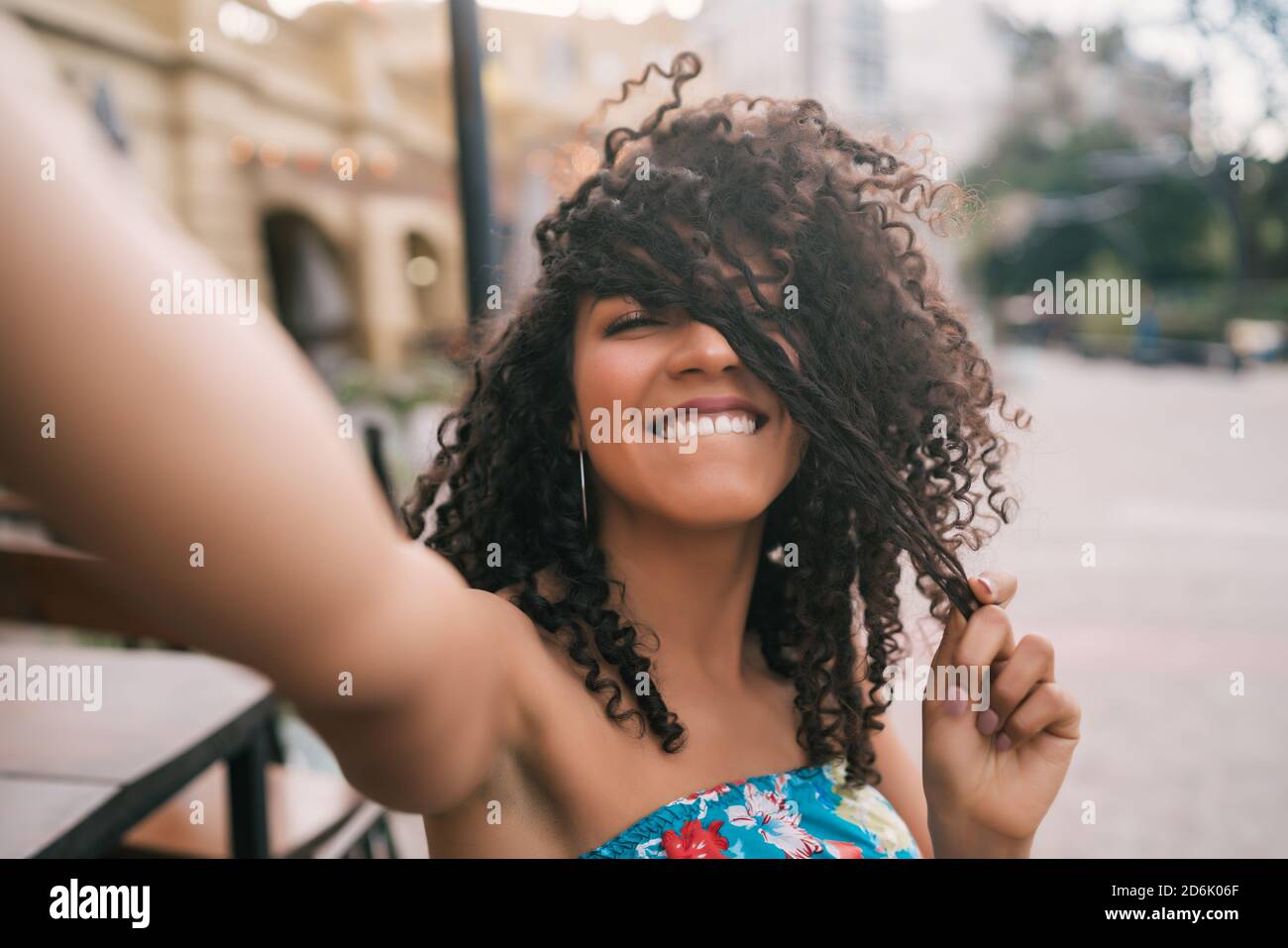 Ritratto di giovane afroamericana che prende un selfie all'aperto in strada. Godendo la vita. Concetto di stile di vita. Foto Stock