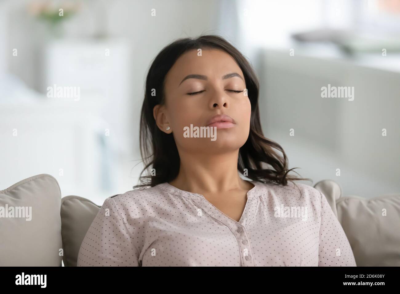 Calma biraciale donna rilassarsi sul divano respirare aria fresca Foto Stock