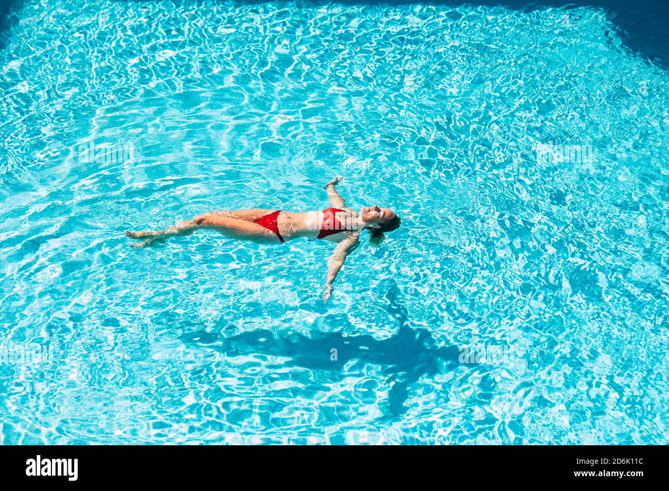 Bella donna nuotare nella piscina blu godendo di vacanze estive vacanza e stile di vita sano - persone che nuotano in acqua e rilassarsi sotto il sole Foto Stock