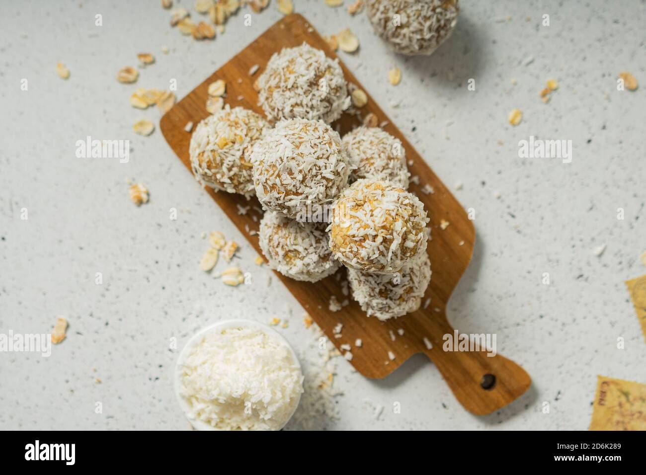 palle energetiche, fiocchi di avena interi e polvere di cocco, dolci a basso contenuto calorico, su sfondo chiaro Foto Stock