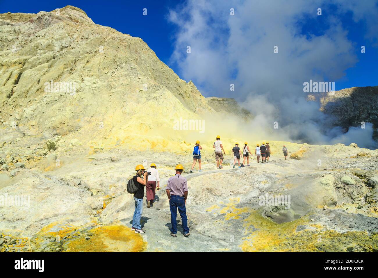 Turisti su White Island, un vulcano attivo al largo della costa della Nuova Zelanda, a piedi verso il lago cratere fumante Foto Stock