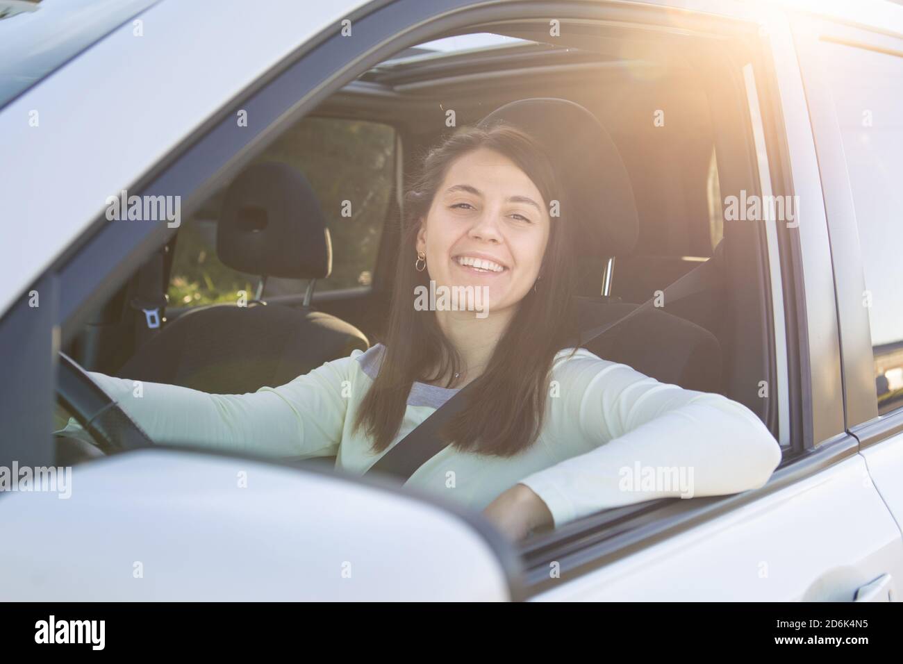 giovane bella donna sorridente che guida l'auto Foto Stock