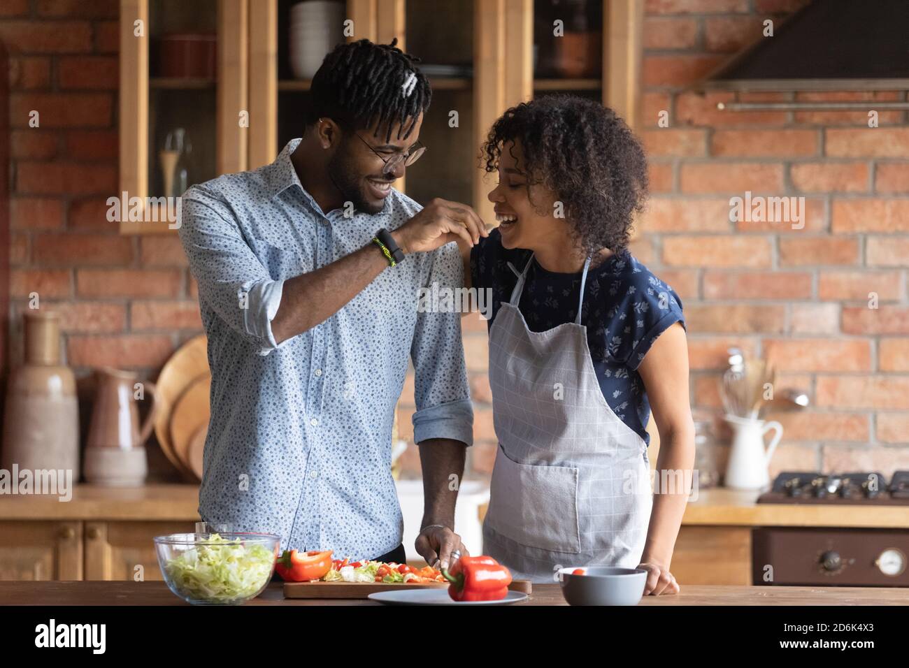 Sorridente giovane coppia biraciale divertirsi a cucinare a casa Foto Stock