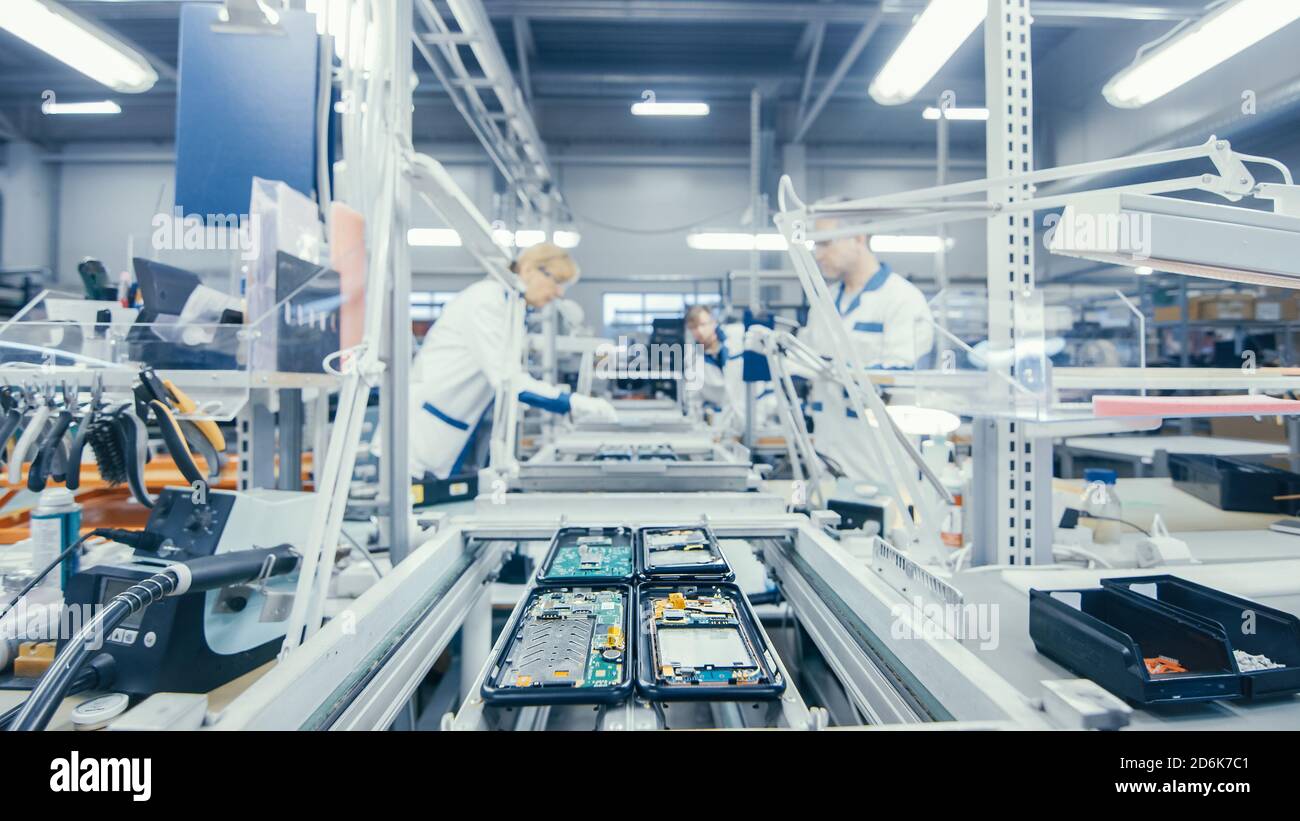 Immagine di un operaio di una fabbrica di elettronica che assembla  manualmente le schede a circuito stampato mentre si trova sulla linea di  assemblaggio. Stabilimento High Tech Foto stock - Alamy