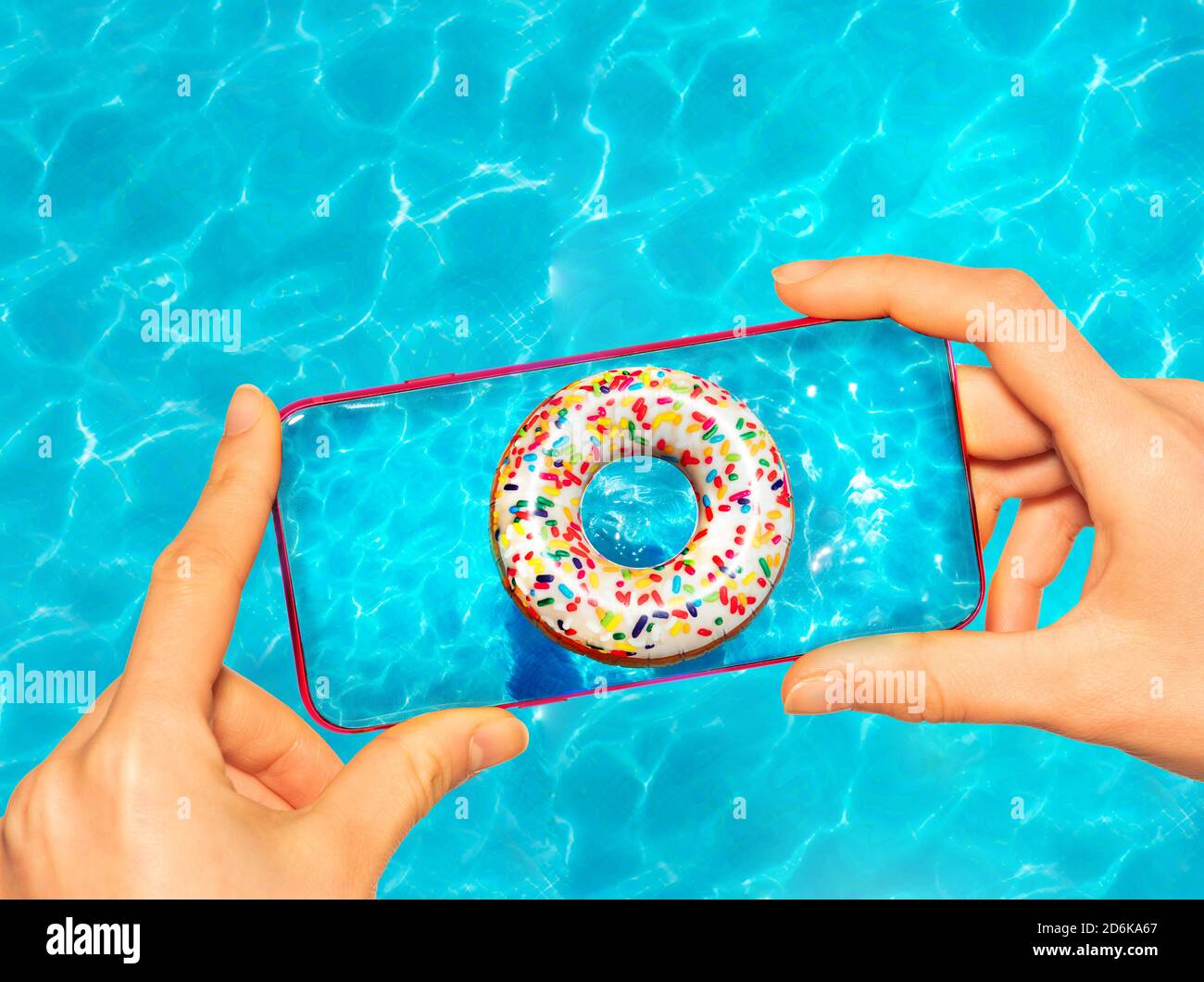 Mani tenere telefono cellulare scattare foto con caramelle gonfiabili ciambella boa in piscina Foto Stock