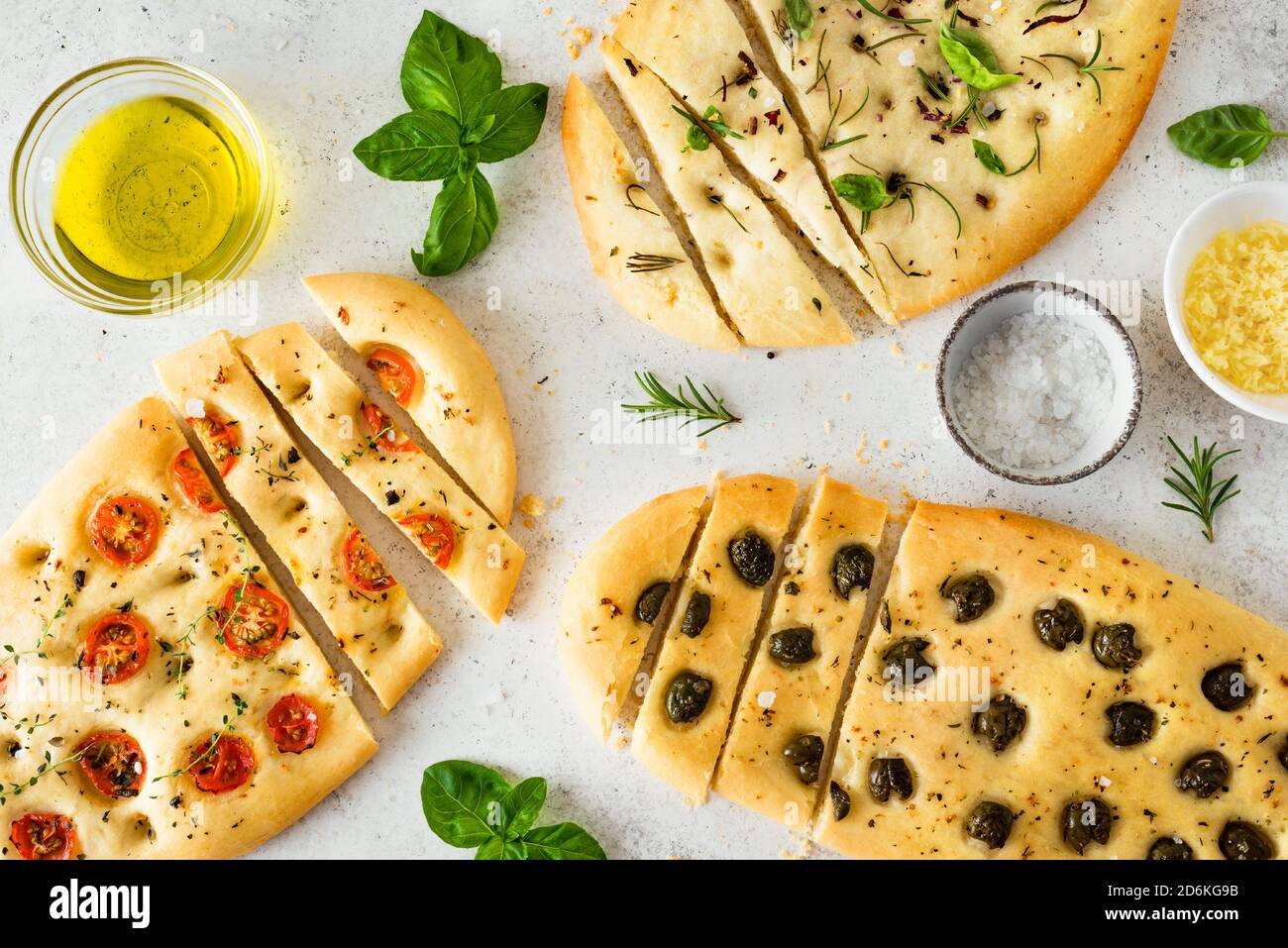 Focaccia con vari ripieno di verdure. Focaccia appena sfornata con pomodori, olive, aglio ed erbe, vista dall'alto. Foto Stock