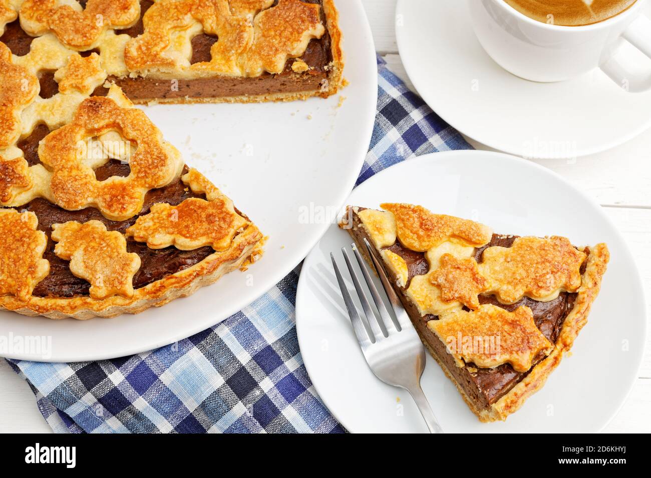 Primo piano torta fatta in casa con formaggio casereccio e prugne e una tazza di caffè. Foto Stock