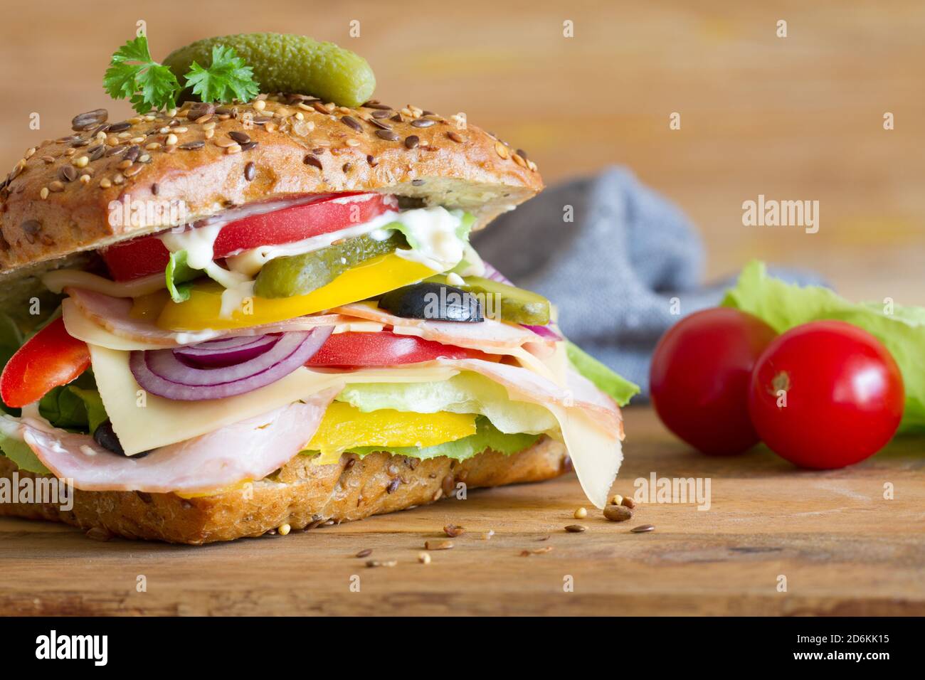 Sandwich appetitoso con carne stagionata, formaggio e verdure su sfondo ligneo Foto Stock