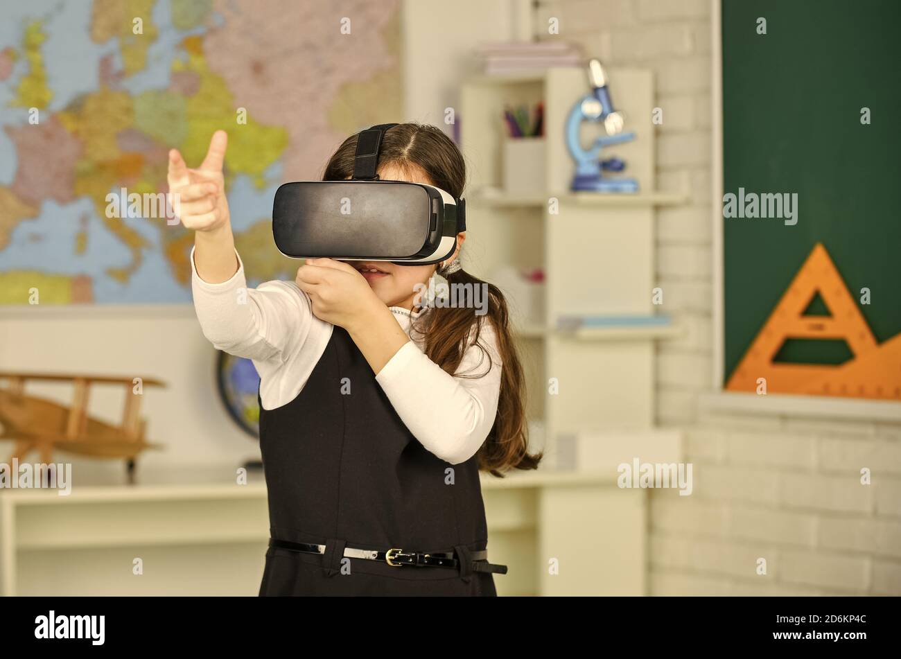 Lavoro virtuale. In una classe informatica. Lavora su un progetto di programmazione. Tecnologia vr. Studente che utilizza la realtà virtuale. Visore realtà virtuale. Scolaretta in classe. Ritorno a scuola. Foto Stock