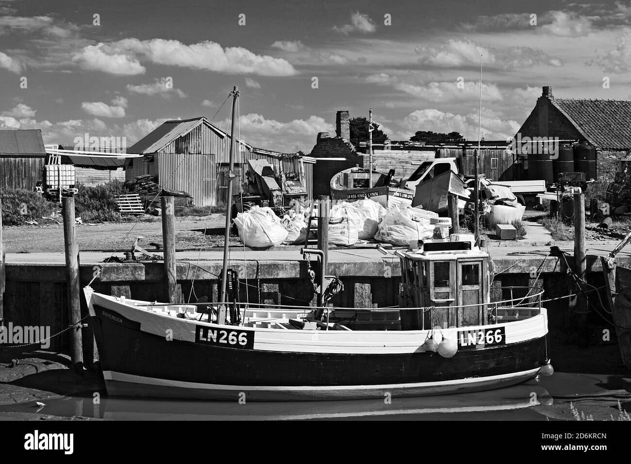 Barca da pesca ormeggiata nel porto con bassa marea a Brancaster Staithe sulla costa di Norfolk, Regno Unito Foto Stock