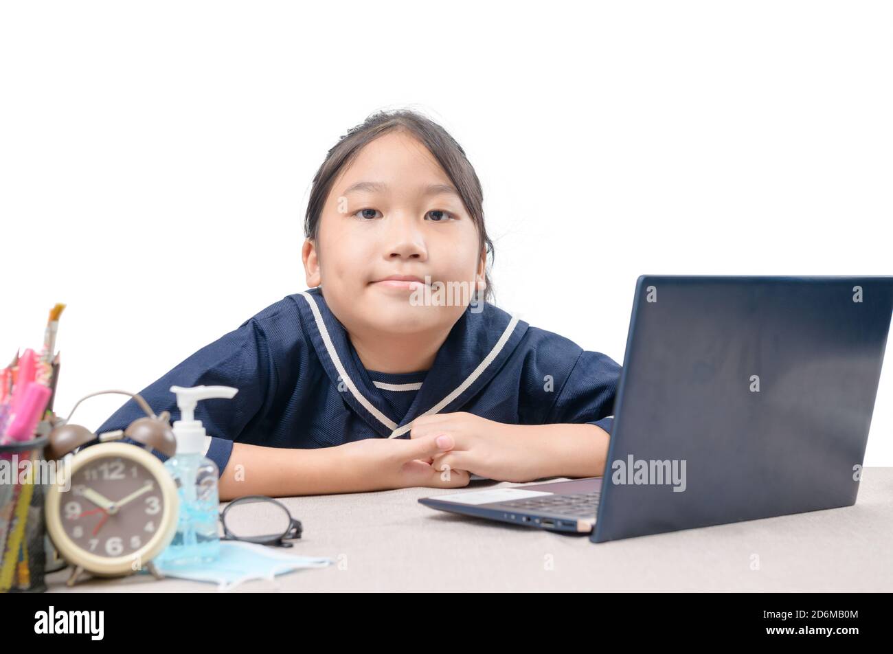 Felice ragazza cute che guarda i video in streaming online sul suo laptop a casa isolato su bianco. Homeschooling, apprendimento a distanza e nuovo concetto normale Foto Stock