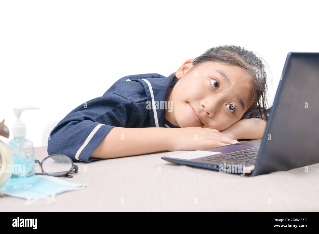 Felice ragazza cute che guarda i video in streaming online sul suo laptop a casa isolato su bianco. Homeschooling, apprendimento a distanza e nuovo concetto normale Foto Stock