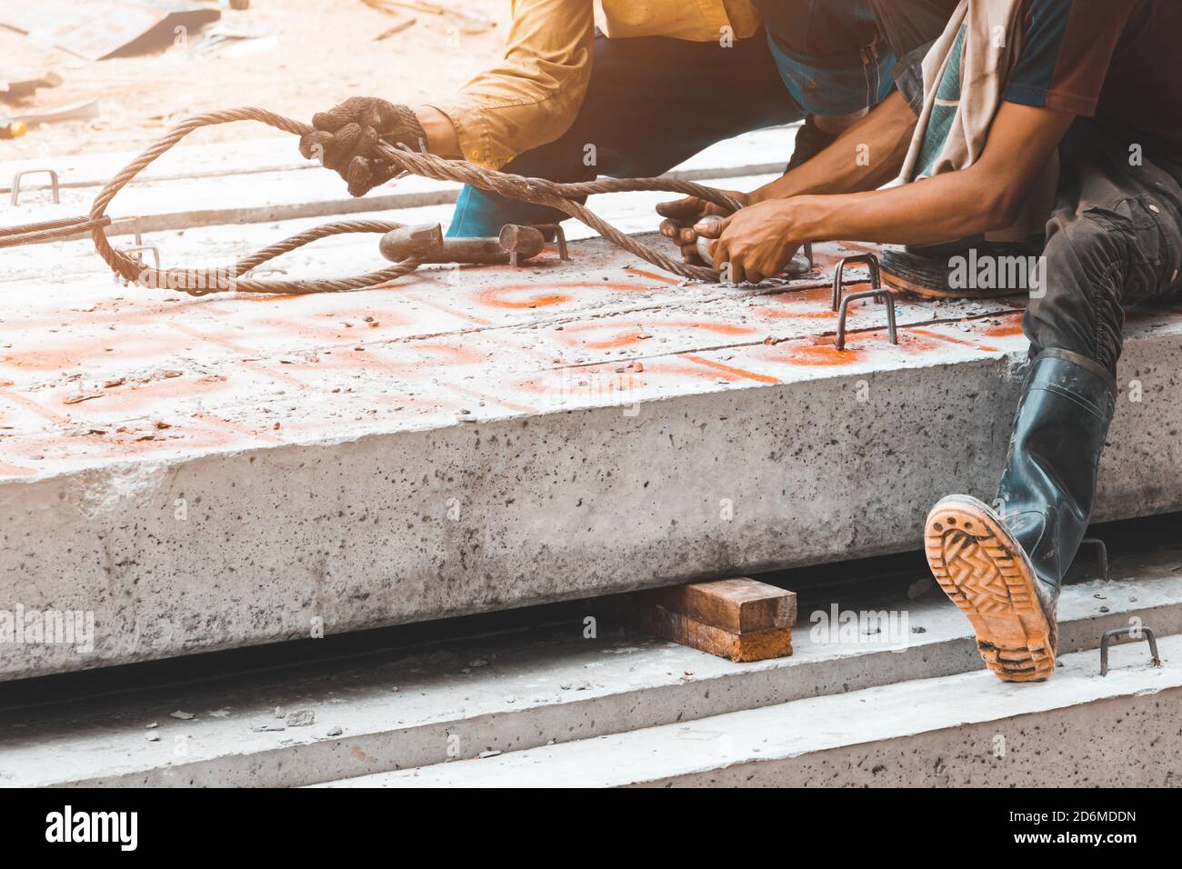 lavoratore spostare pali di cemento palo pilastri su terra da imbracatura in cantiere Foto Stock
