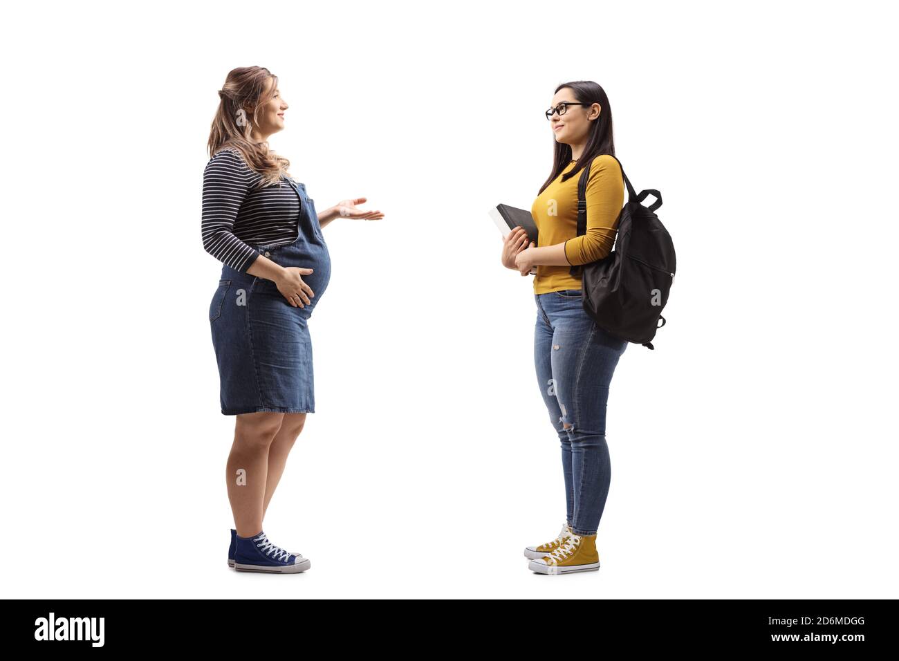 Foto di profilo a lunghezza intera di una donna incinta che parla con una studentessa isolata su sfondo bianco Foto Stock