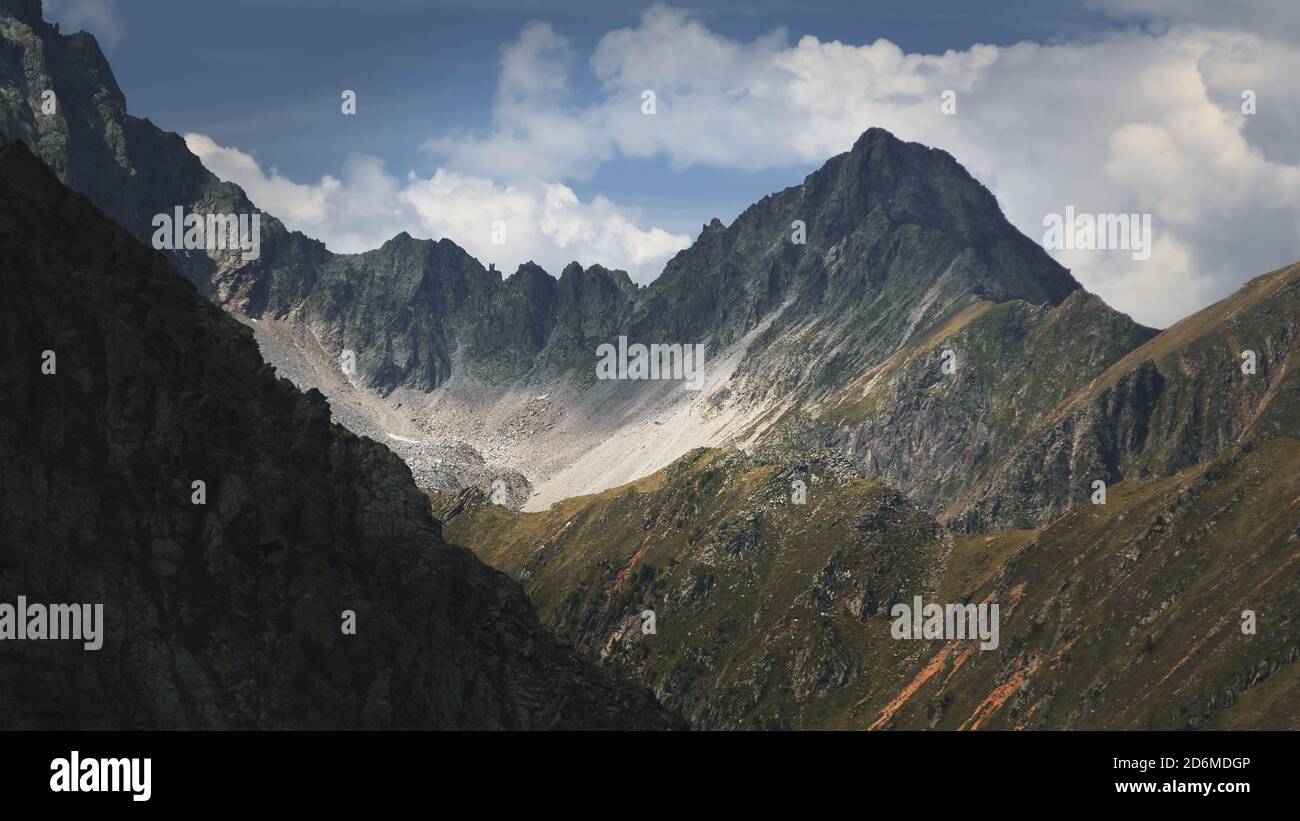 Le alte montagne delle Alpi austriache a Kuhtai durante la stagione estiva. Il sole illumina il bellissimo paesaggio. Foto Stock