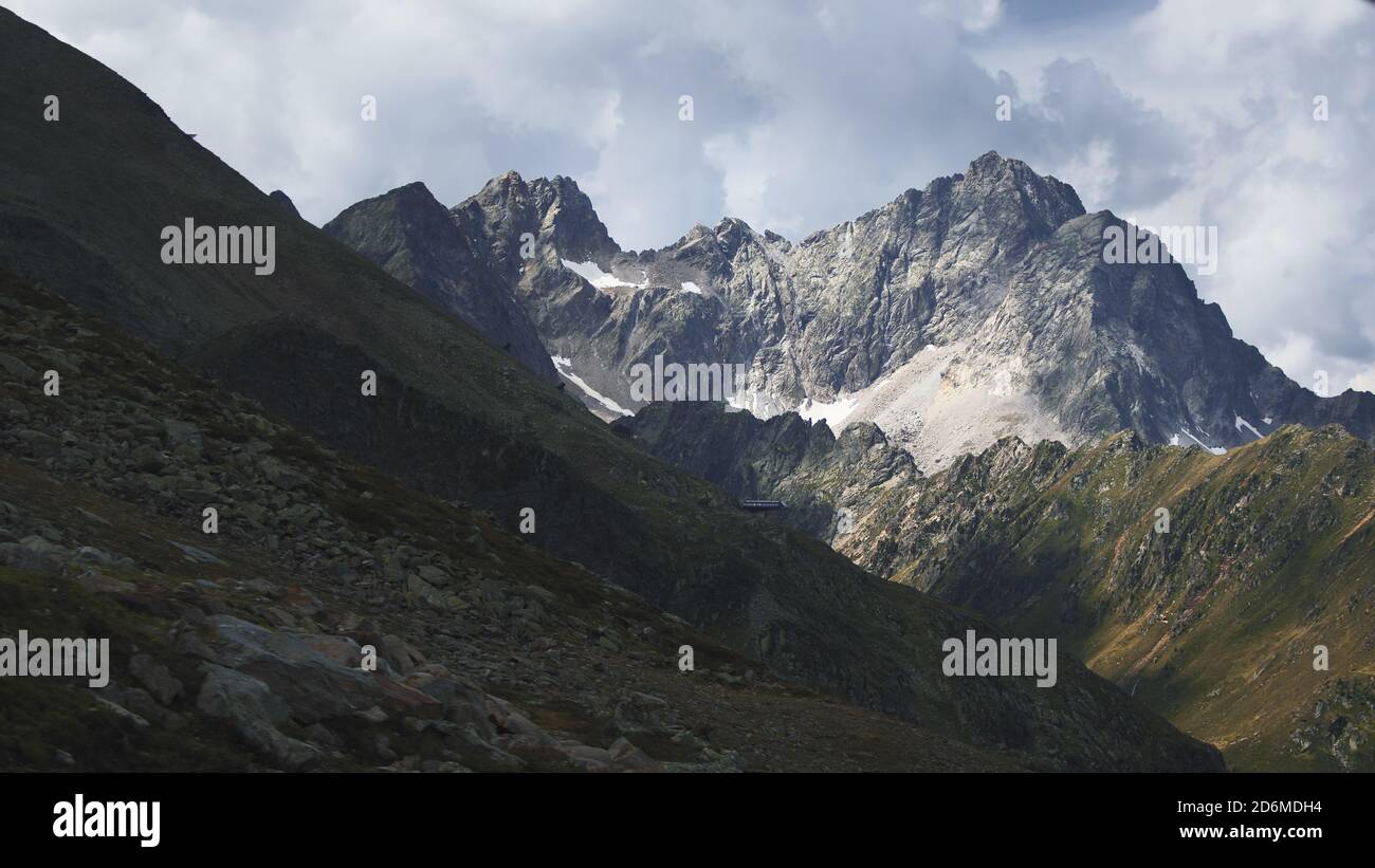 Foto aerea delle alte montagne delle Alpi austriache a Kuhtai durante la stagione estiva. Il sole illumina il bellissimo paesaggio. Foto Stock