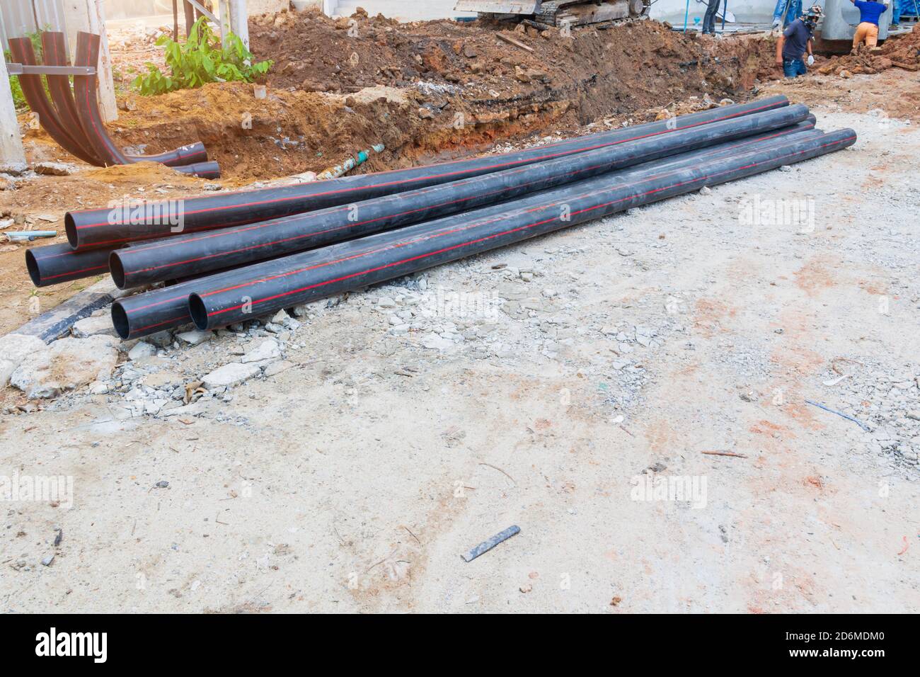 Pali tubi nero riparare l'acqua sul terreno Foto Stock