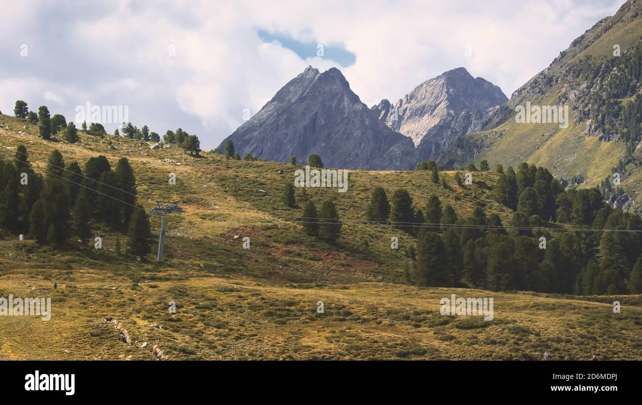 Foto aerea delle alte montagne delle Alpi austriache a Kuhtai durante la stagione estiva. Il sole illumina il bellissimo paesaggio. Foto Stock