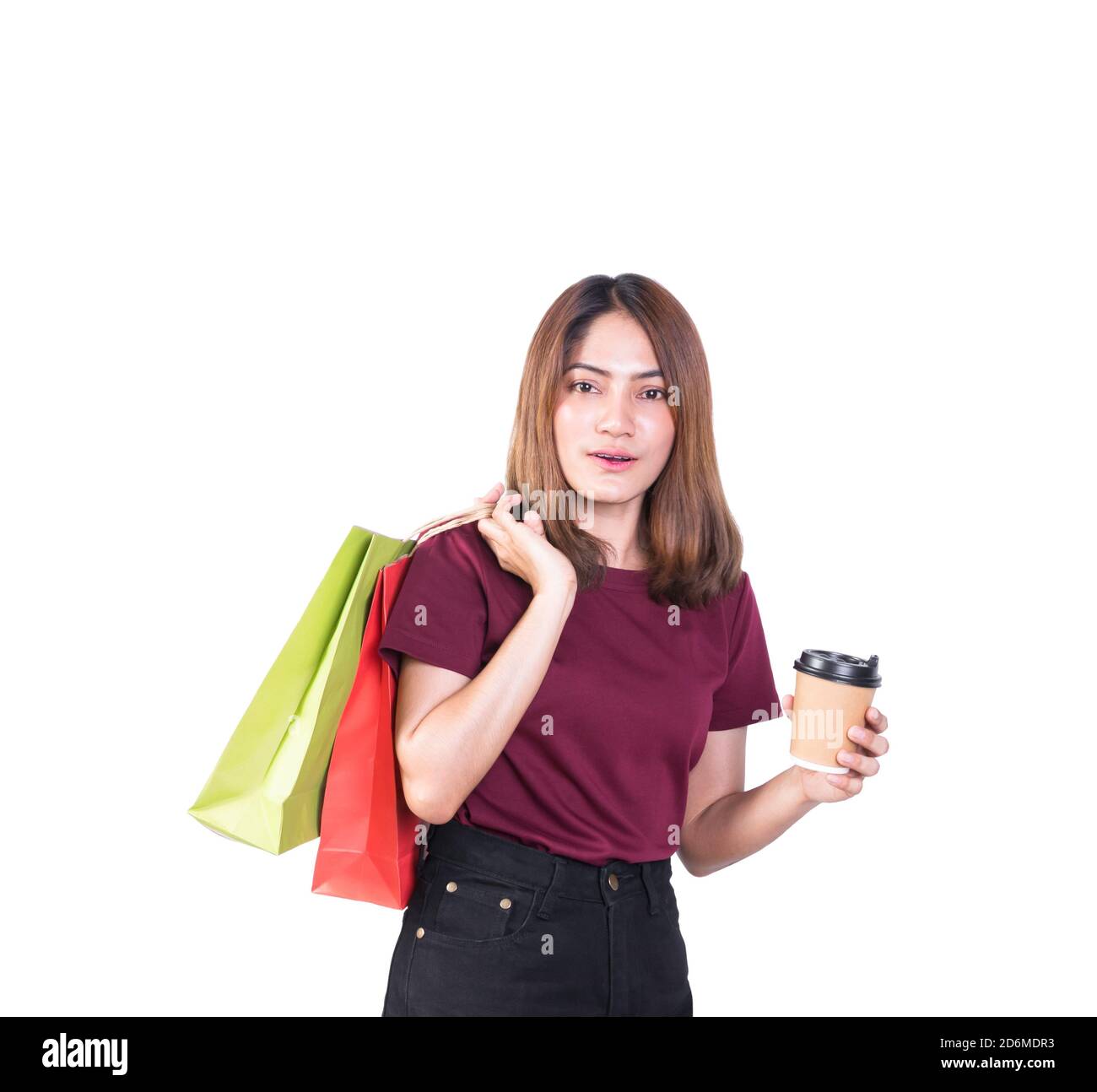 Donna piuttosto sorridente che tiene borse di carta e tazza di cartone di caffè nello shopping. Su sfondo bianco e guardare la macchina fotografica Foto Stock
