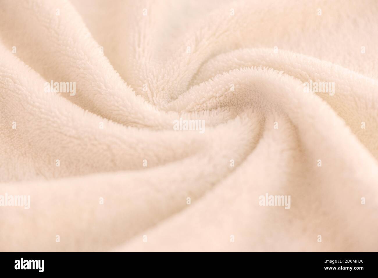 Un morbido e accogliente plaid fatto di tessuto bianco con un pile giace in belle pieghe Foto Stock