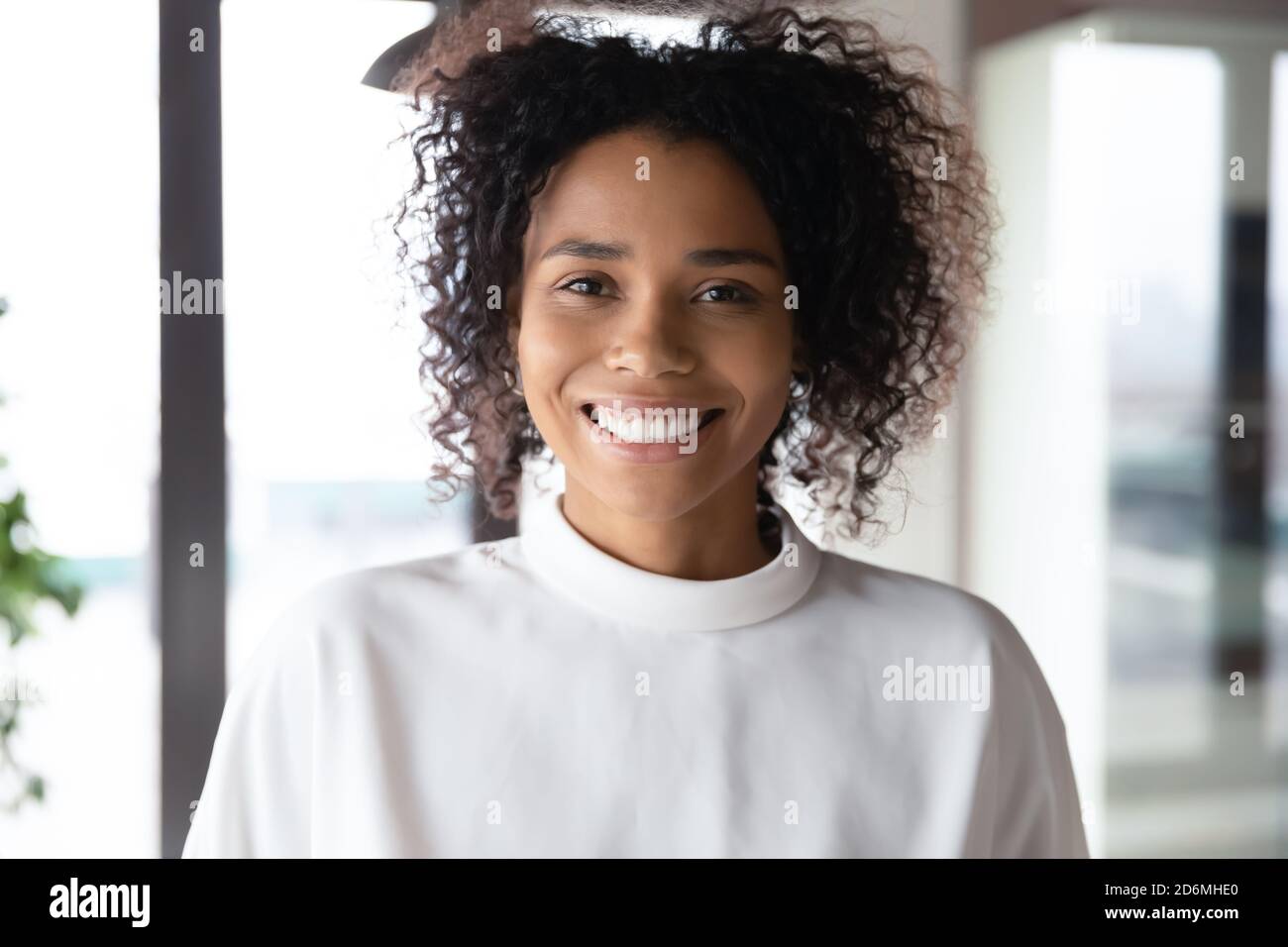 Primo piano ritratto di sorridente giovane donna d'affari afroamericana. Foto Stock