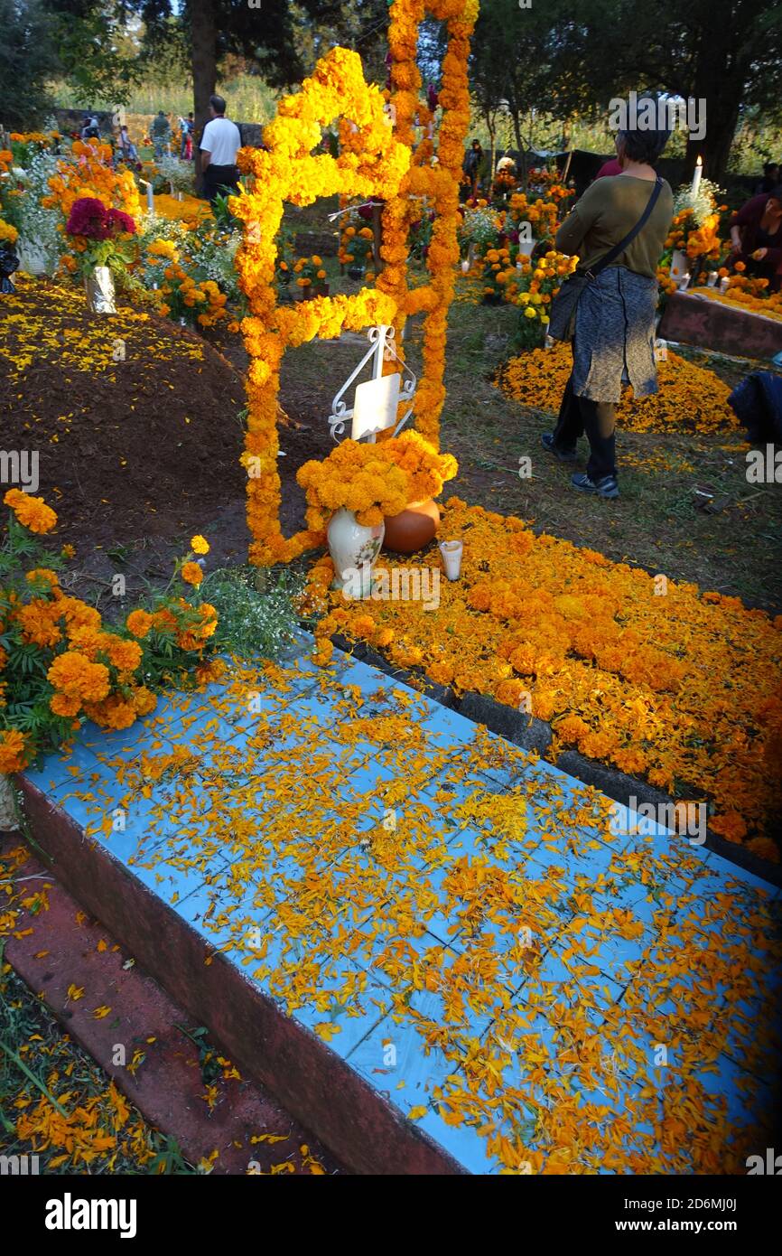 I marigolds conosciuti in Messico, come 'il fiore dei morti' decorano tombe a Patzcuaro durante il giorno dei morti, quando le famiglie ricordano i loro cari. Foto Stock