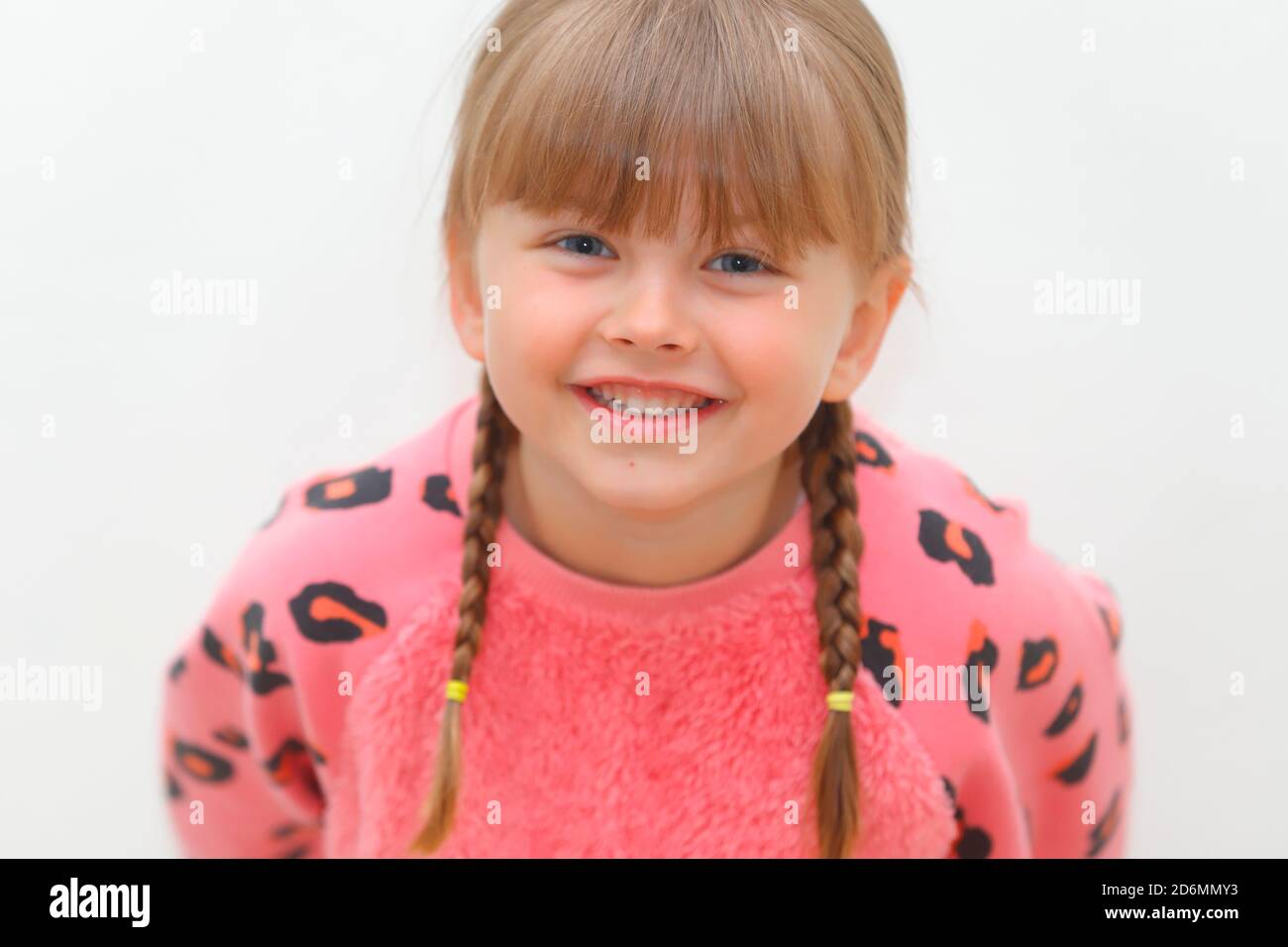 Una ragazza felice di 5 anni con i pigtail. Foto Stock