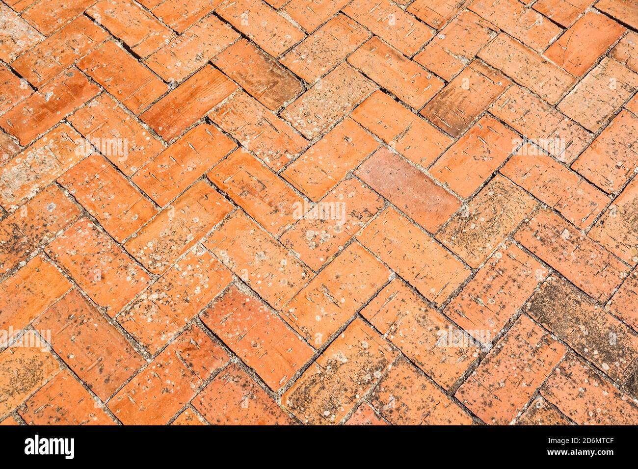 Pavimentazione in mattoni posta in Spike, sfondo urbano e struttura di un cortile spagnolo Foto Stock