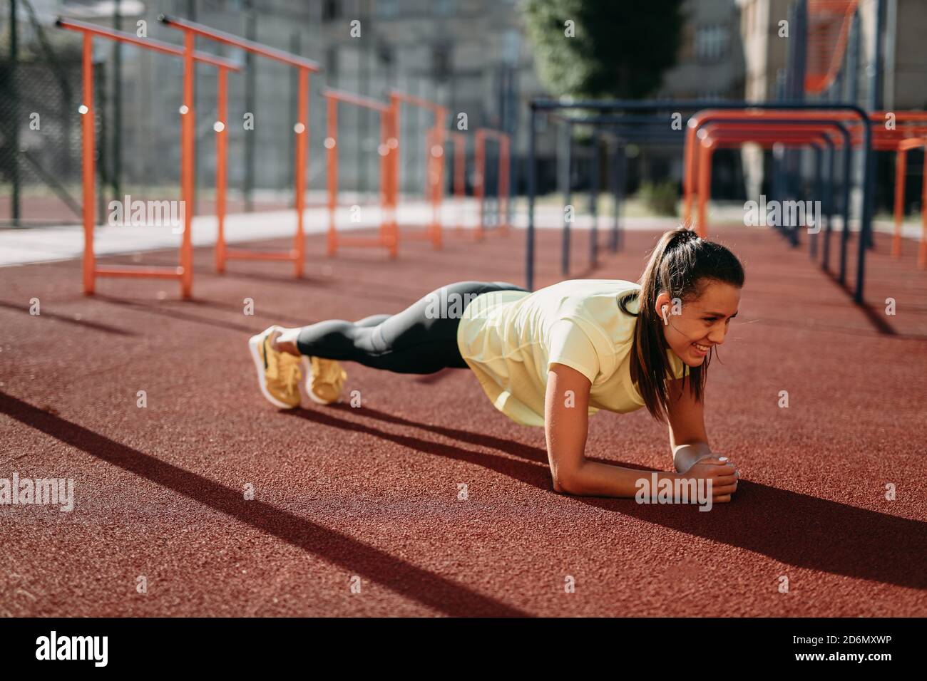 Bruna attiva e felice in piedi in posizione tavola all'aperto Foto Stock