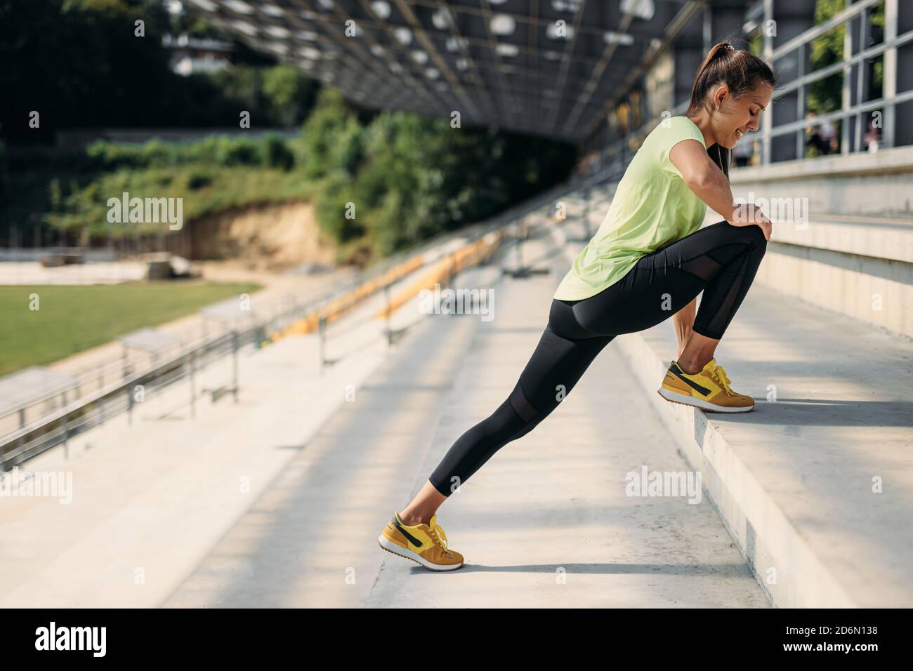 Vista laterale delle gambe che si allungano per donna fitness sulle scale Foto Stock