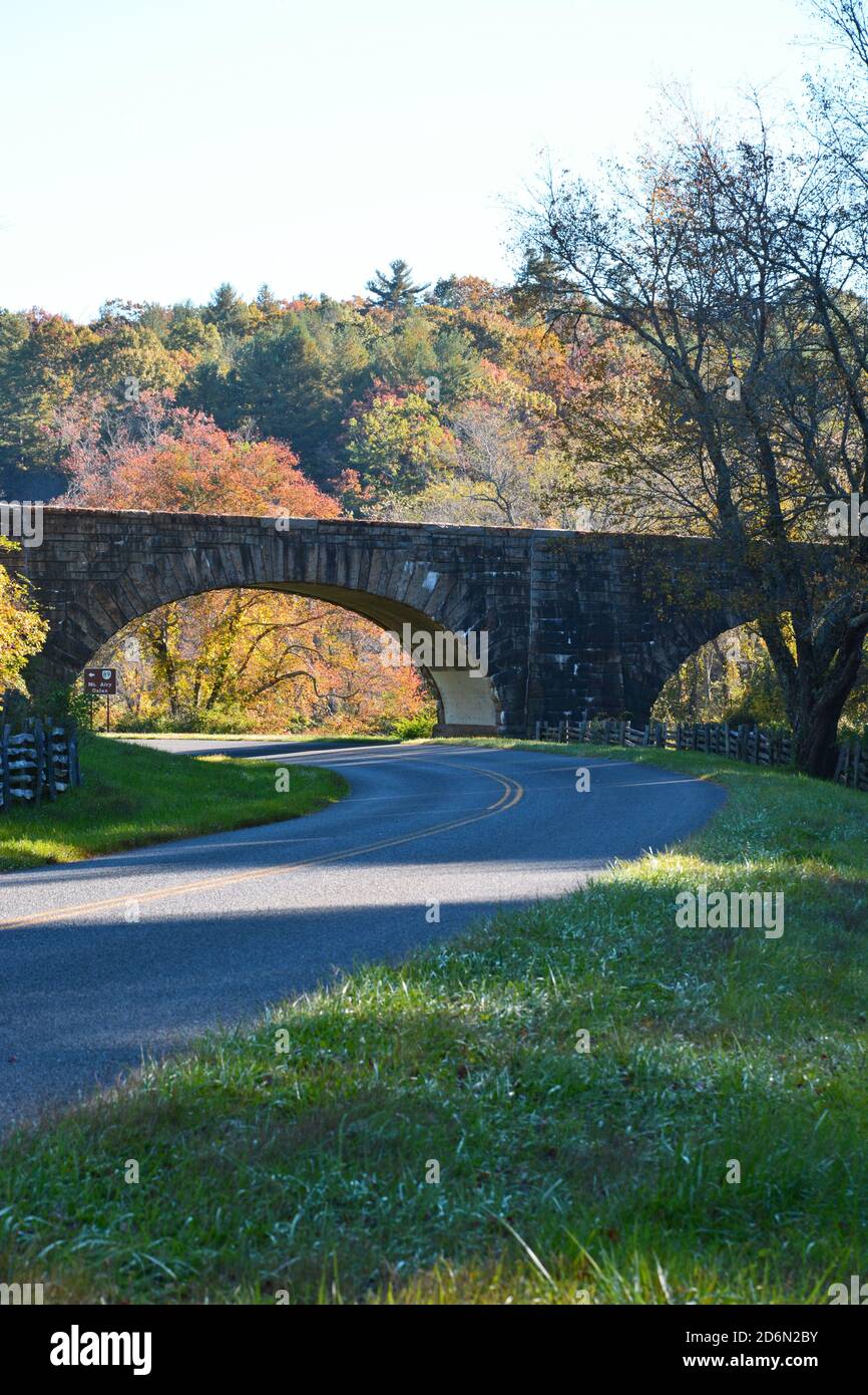 Un ponte di pietra è in contrasto con i colori autunnali sulla Blue Ridge Parkway in Virginia. Foto Stock