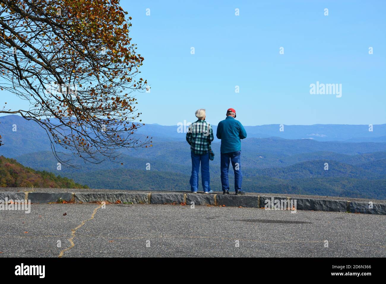 Una coppia più anziana si affaccia sulla catena montuosa durante l'autunno in un'escursione panoramica sulla Blue Ridge Parkway, nella Carolina del Nord. Foto Stock