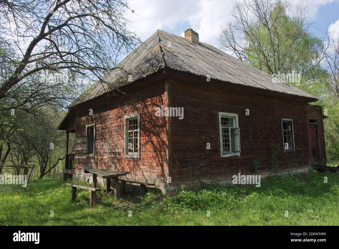 Una casa di legno abbandonata nella foresta. Una vecchia casa di legno. Costruzione con tetto in ardesia. Foto Stock