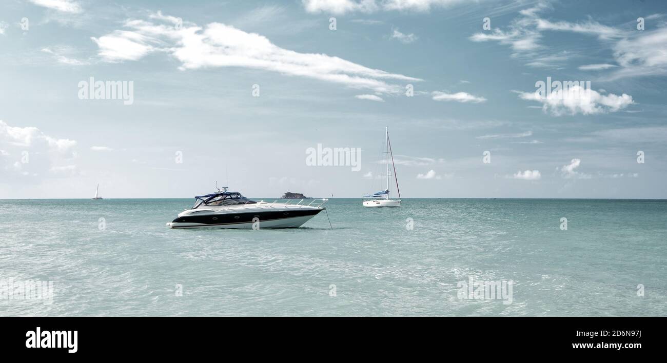 Attraente luminosa vista di esotici e coloratissimi bella spiaggia di Marina di Antigua St. Johns con la barca in acqua blu e il cielo con piccole nuvole nel tempo soleggiato outdoor su sfondo naturale, la foto in orizzontale Foto Stock